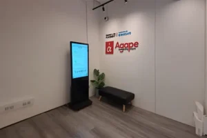 Interactive digital signage kiosk showcasing employee achievements, company news, and important announcements at the Agape office.