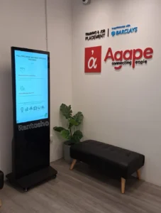 Interactive digital signage kiosk showcasing employee achievements, company news, and important announcements at the Agape office.
